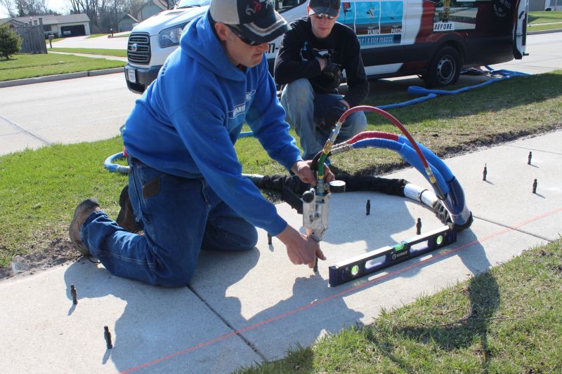 Man working injecting polyurethane foam into a concrete slab