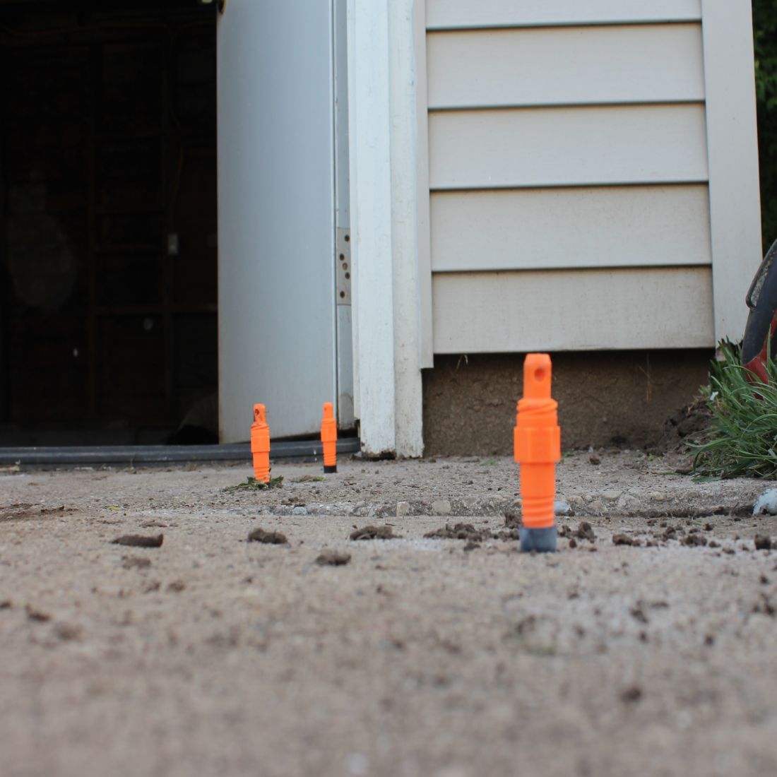 An even concrete driveway with three orange injector ports