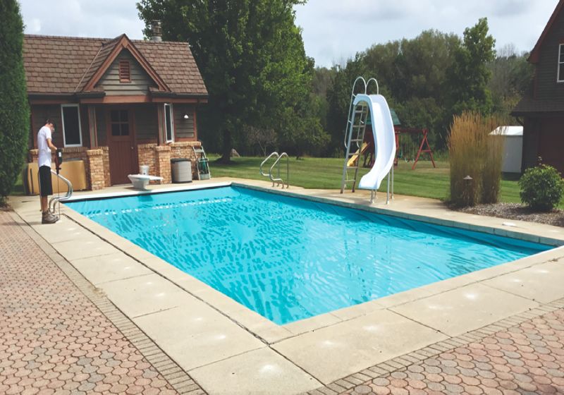 A house with a large pool and an even pool deck